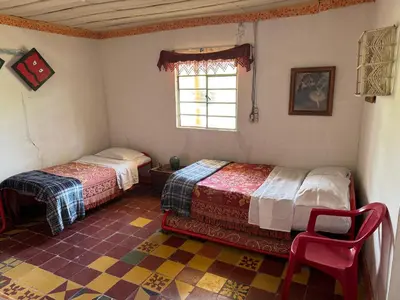 a bedroom with two beds and a window at Casa de campo a 5 minutos from Sonsón in Sonsón