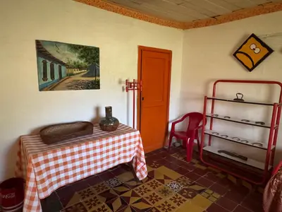 a room with a table and a red chair at Casa de campo a 5 minutos from Sonsón in Sonsón