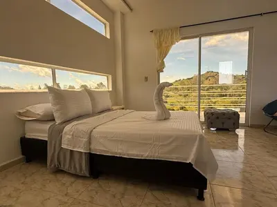 a bedroom with a large bed with a large window at Villa de lujo con piscina, jacuzzi y vista maravillosa in El Peñol