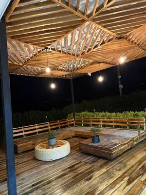 a wooden pergola with two potted plants on a deck at Villa de lujo con piscina, jacuzzi y vista maravillosa in El Peñol