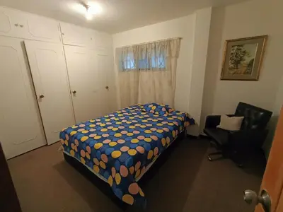 a bedroom with a bed and a chair and a window at Casa Clásica Zona Centro Medellín, Casa Villa para 8H in Medellín