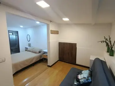 a bedroom with a bed and a couch and a mirror at Aparta Hotel Campestre para 5H Poblado San Lucas apt 112 in Medellín