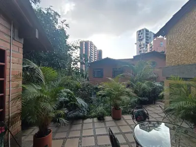 a courtyard with palm trees and a building at Aparta Hotel Campestre para 5H Poblado San Lucas apt 112 in Medellín