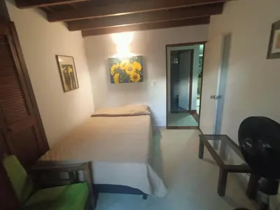 a bedroom with a bed and a chair and a mirror at Aparta Hotel Campestre para 5H Poblado San Lucas apt 112 in Medellín