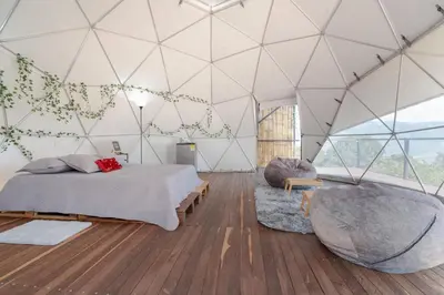 a room with a bed and a chair in a tent at Deluxe Glamping Domo in Copacabana