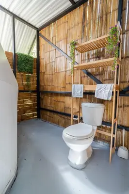 a bathroom with a toilet in a wooden wall at Deluxe Glamping Domo in Copacabana