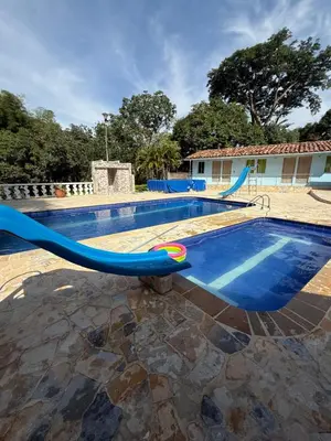 a swimming pool with a blue slide in front of a house at Finca san julian in San Jerónimo
