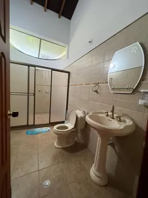 a bathroom with a sink and a toilet and a mirror at Finca san julian in San Jerónimo