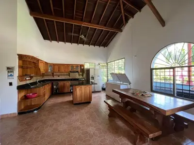 a large kitchen with wooden cabinets and a wooden table at Finca san julian in San Jerónimo