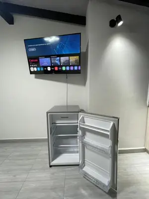 a refrigerator in a room with a tv on the wall at Hotel boutique Olaya 54 in Medellín