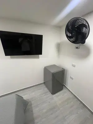 a room with a television and a fan on the wall at Hotel boutique Olaya 54 in Medellín