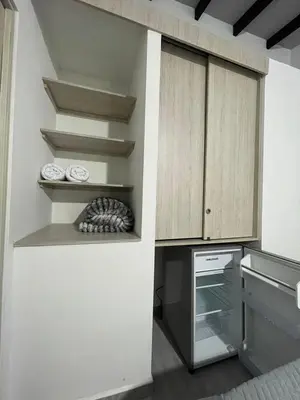 a kitchen with white walls and wooden cabinets at Hotel boutique Olaya 54 in Medellín