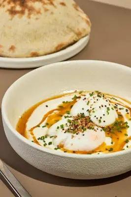 a bowl of eggs and bread on a table at The Host Medellin Adults Only in Medellín