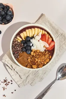 a bowl of food with fruit and nuts on a table at The Host Medellin Adults Only in Medellín