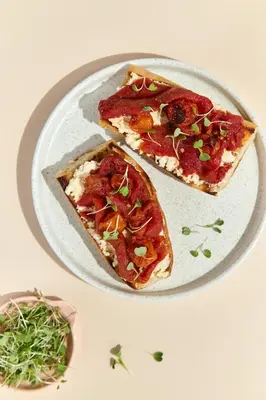 two slices of pizza on a plate on a table at The Host Medellin Adults Only in Medellín