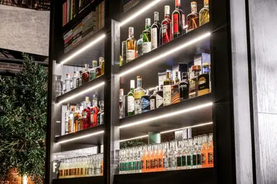 a bar with a display of alcohol bottles at The Host Medellin Adults Only in Medellín