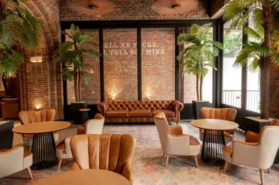 a lobby with a couch and tables and chairs at The Host Medellin Adults Only in Medellín