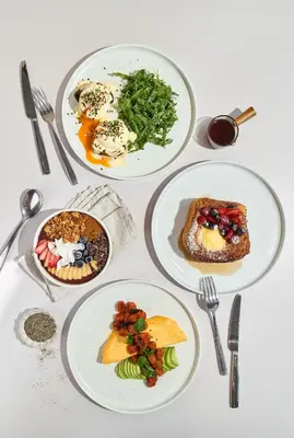 a white table with plates of food on it at The Host Medellin Adults Only in Medellín