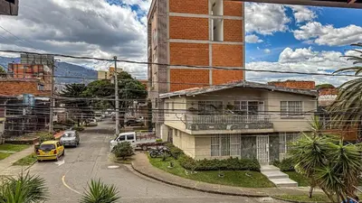 a building with a yellow car parked next to a street at Urban Lofts Laureles 40 in Medellín