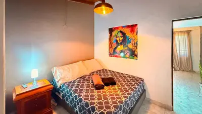 a bedroom with a bed and a painting on the wall at Urban Lofts Laureles 40 in Medellín