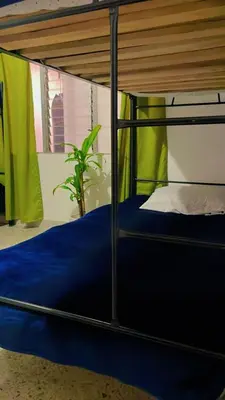 a bed with a blue comforter in a room at Hostal Abba in Medellín