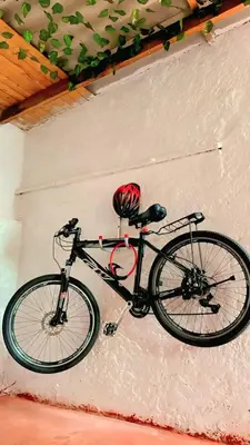 a bike parked against a wall with a helmet on it at Hostal Abba in Medellín