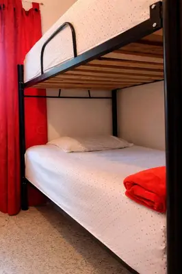 two bunk beds in a room with a red curtain at Hostal Abba in Medellín