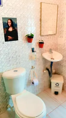 a bathroom with a white toilet and a sink at Hostal Abba in Medellín