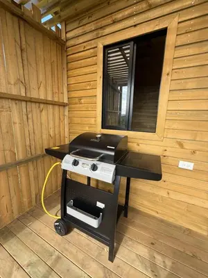 a small stove in a wooden room with a mirror at Alto Paraiso Glamping 