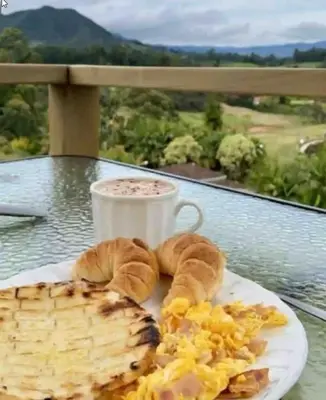 a plate of breakfast food and a cup of coffee at Alto Paraiso Glamping 