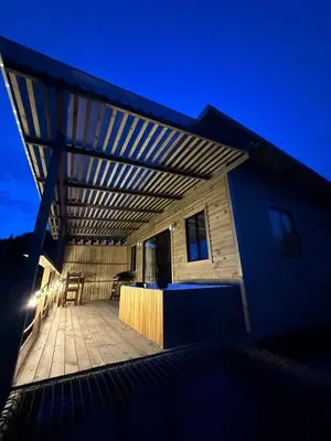 a pergola over a patio of a house at night at Alto Paraiso Glamping 