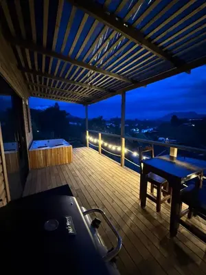a deck with a table and a bench on a balcony at Alto Paraiso Glamping 