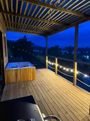 a large wooden deck with a hot tub on it at Alto Paraiso Glamping 