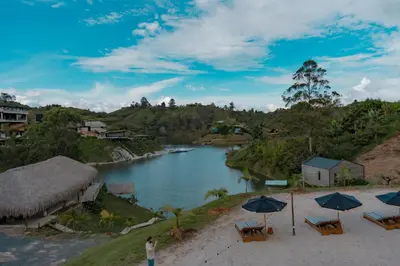 a person standing on a beach next to a river at Okai by Bernalo Hotels in Guatapé