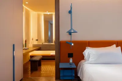 a hotel room with a bed and a bathroom at The Cut Hotel in Medellín