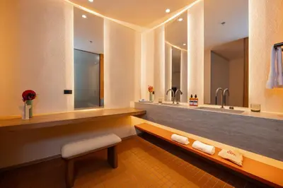a bathroom with two sinks and two mirrors at The Cut Hotel in Medellín
