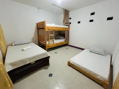 a room with two beds and a bunk bed at Casa Almanik Hostel in Medellín