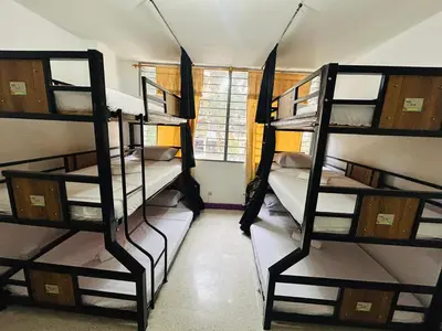 a room with three bunk beds and a window at Casa Almanik Hostel in Medellín