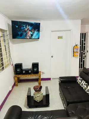 a living room with a couch and a flat screen tv at Casa Almanik Hostel in Medellín
