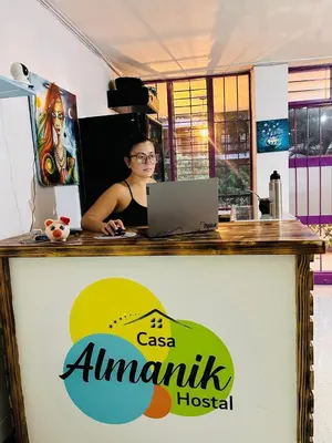 a woman sitting at a counter with a laptop at Casa Almanik Hostel in Medellín