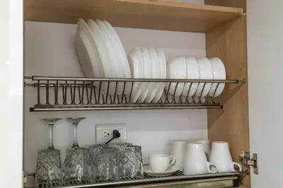 a shelf with plates and cups and glasses on it at Coffee Spring Studio Medellin in Medellín