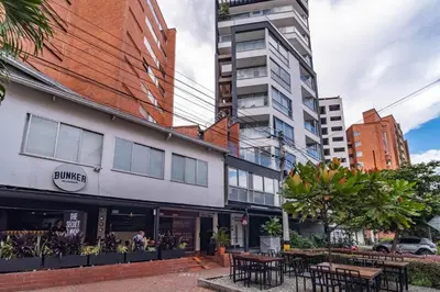 a building with tables and chairs in a city at Coffee Spring Studio Medellin in Medellín