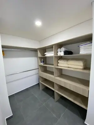a walk in closet with wooden shelves and towels at calido y tranquilo apartamento in Sabaneta