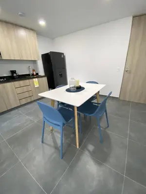a kitchen with a white table and blue chairs at calido y tranquilo apartamento in Sabaneta