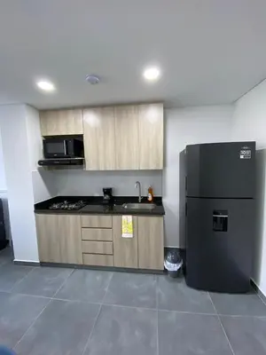 a kitchen with a black refrigerator in a room at calido y tranquilo apartamento in Sabaneta