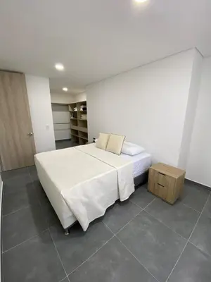 a bedroom with a large white bed and a table at calido y tranquilo apartamento in Sabaneta
