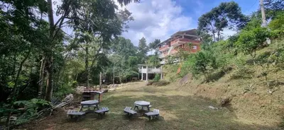 a group of picnic tables on a hill with a building at La Morada Del Gavilucho in San Carlos