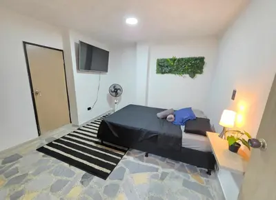 a bedroom with a bed and a flat screen tv at Acogedor apto laureles estadio in Medellín