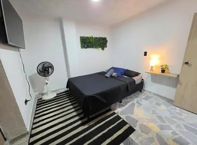 a bedroom with a bed in a room with a fan at Acogedor apto laureles estadio in Medellín