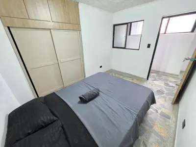 a bedroom with a large bed in a room with windows at Acogedor apto laureles estadio in Medellín